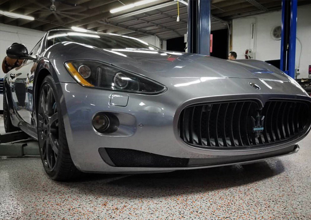 Maserati sports car in a garage, highlighting its sleek design and distinctive grille, relevant to discussions about luxury car maintenance.